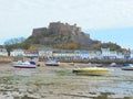 Castle on hill and boats in harbour