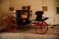 Castle interior, Antique black and red carriage, wooden high wheels, noble coat of arms painted on the carriage door, renaissance Royalty Free Stock Photo