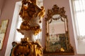 Castle interior. Antique mirror in a carved frame. Hall with a baroque staircase. Castle Duchcov, Czech Republic