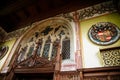 Castle interior, colored plaster, wall painting, gothic carved furniture, coat of arms, window with stained glass, grand hall of