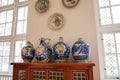 Castle interior, Large porcelain vases standing in corridor on wooden cabinet, blue-white and yellow-green floral patterns,