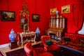 Castle interior. Men`s salon, used as a smoking room for gentlemen. Red room with wooden antique secretary, soft armchairs and