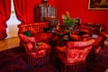 Castle interior. Men`s salon, used as a smoking room for gentlemen. Red room with wooden antique secretary, soft armchairs and