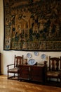 Castle interior, renaissance furniture, antique carved chest, carpet tapestry, white-blue porcelain service, wooden armchairs,