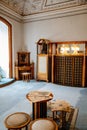 Castle interior, Secession art nouveau style round table, stools, old newspapers, wardrobe, crystal lamps, blue carpet,