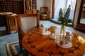 Castle interior, Secession art nouveau style, round wooden inlaid table, porcelain cups and vases, flowers, armchair, renaissance