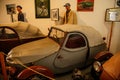 Castle interior, small retro car with tarpaulin on Jawa 250 engine, racing car exhibition, mannequins male racers, renaissance