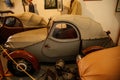 Castle interior, small retro car with tarpaulin on Jawa 250 engine, racing car exhibition, mannequins male racers, renaissance