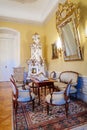 Castle interior. Tea room, wood carved chairs and table. Mirror in a gilded frame. Antique ceramic stove. Renaissance castle