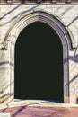 Castle like gothic pointed arch in block wall with black inside and bricks on ground - background or frame
