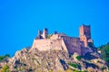 Castle ruins on hugh rock hill, against blue sky in late afternoon light, in northern Italy Royalty Free Stock Photo
