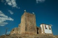 Castle and square tower over rocky hill with cross Royalty Free Stock Photo