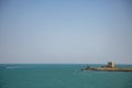 A castle tower on the coast the Adriatic Sea with a white boat on the water Royalty Free Stock Photo