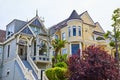 Castle tower on yellow house with large bay windows beside blue house with long staircase and ladder Royalty Free Stock Photo