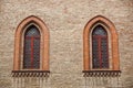 Castle window in a medieval style. Double arched window on a facade of medieval wall. Biforium - ancient window with Royalty Free Stock Photo