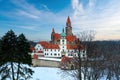 Castle in winter. Romantic fairytale castle in picturesque highland landscape, covered in snow. Castle with white church, high Royalty Free Stock Photo