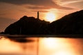 Castlepoint lighthouse at sunrise creating a silhouette of the rock and lighthouse