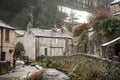 Castleton Beautiful old rural idyllic village cottage with smoke from chimney Peak District river peacefully flowing during winter Royalty Free Stock Photo