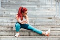 Attractive casual active woman smiling and working out on stairs. Stretching and running training. Fitness concept Royalty Free Stock Photo