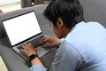 Asian man lying on comfortable sofa at home and working online with computer laptop. Royalty Free Stock Photo