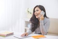 Casual asian woman making a phone call at home using smart phone Royalty Free Stock Photo