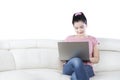 Casual Asian woman uses laptop on sofa Royalty Free Stock Photo