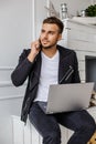 A man using laptop near fireplace. Royalty Free Stock Photo