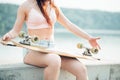 Black and white image of young woman sitting on stairs holding longboard Royalty Free Stock Photo