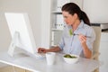 Casual brunette businesswoman eating a salad at her desk Royalty Free Stock Photo