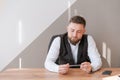 Casual business man bearded, sitting at table with pen in his hand, thinking