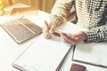 Casual business man using mobile smart phone working, taking note, schedule on paper notebook, reading e book application. E Royalty Free Stock Photo