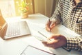 Casual business man using mobile smart phone working, taking note, schedule on paper notebook, reading e book application. E Royalty Free Stock Photo