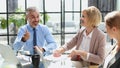 Casual business people around conference table in office Royalty Free Stock Photo