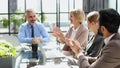 Casual business people around conference table in office Royalty Free Stock Photo