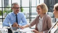 Casual business people around conference table in office Royalty Free Stock Photo