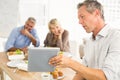 Casual business people looking at tablet while lunch Royalty Free Stock Photo