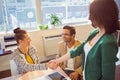 Casual business people shaking hands at desk and smiling Royalty Free Stock Photo