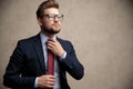 Casual businessman adjusting his tie and hopefully looking away Royalty Free Stock Photo