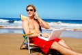 Casual Businessman Relaxing at the Beach with Laptop Computer Ta Royalty Free Stock Photo