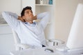 Casual businessman relaxing at desk leaning back