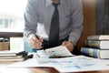 Casual businessman sitting at his desk online working. in the office with new startup project and graph data documents on his desk Royalty Free Stock Photo