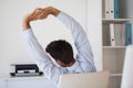 Casual businessman stretching in swivel chair