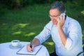 Casual businessman taking notes and having a phone call Royalty Free Stock Photo