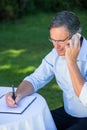 Casual businessman taking notes and having a phone call Royalty Free Stock Photo