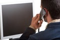 Casual Businessman Talking over the Phone and Looking at a Computer Screen Royalty Free Stock Photo