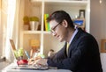 Casual businessman working in office, sitting at desk, typing on keyboard, looking at computer screen Royalty Free Stock Photo