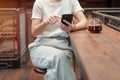 Casual Businesswoman holding and using smartphone for sms messages, young woman typing touchscreen mobile phone in coffee cafe or Royalty Free Stock Photo