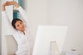 Casual businesswoman stretching at her desk Royalty Free Stock Photo