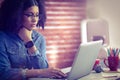 Casual businesswoman using laptop and smartwatch