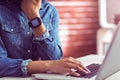 Casual businesswoman using laptop and smartwatch Royalty Free Stock Photo